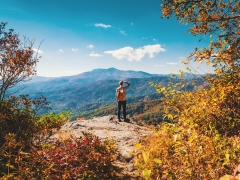  A person at the top of a mountain looking at the horizon. 