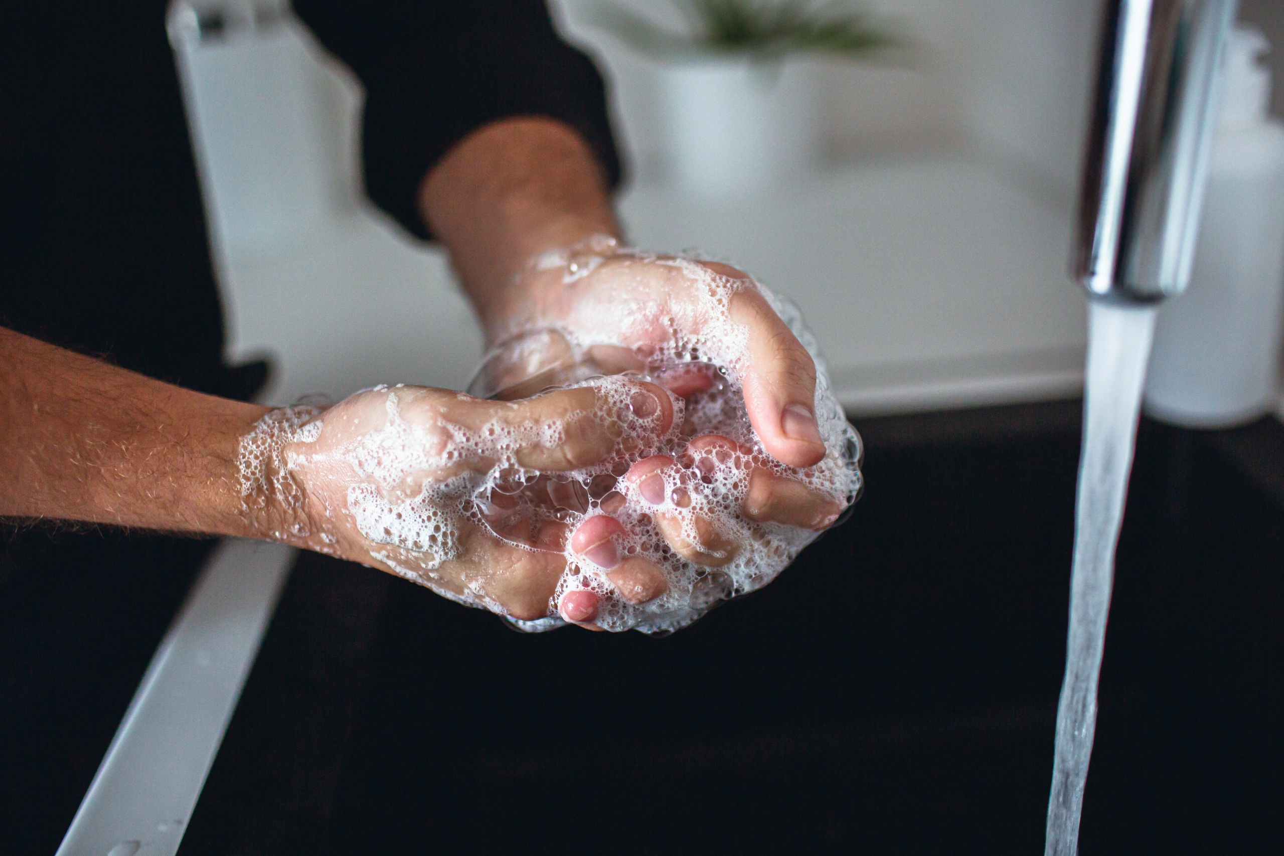 A man washing his hands at the sink.