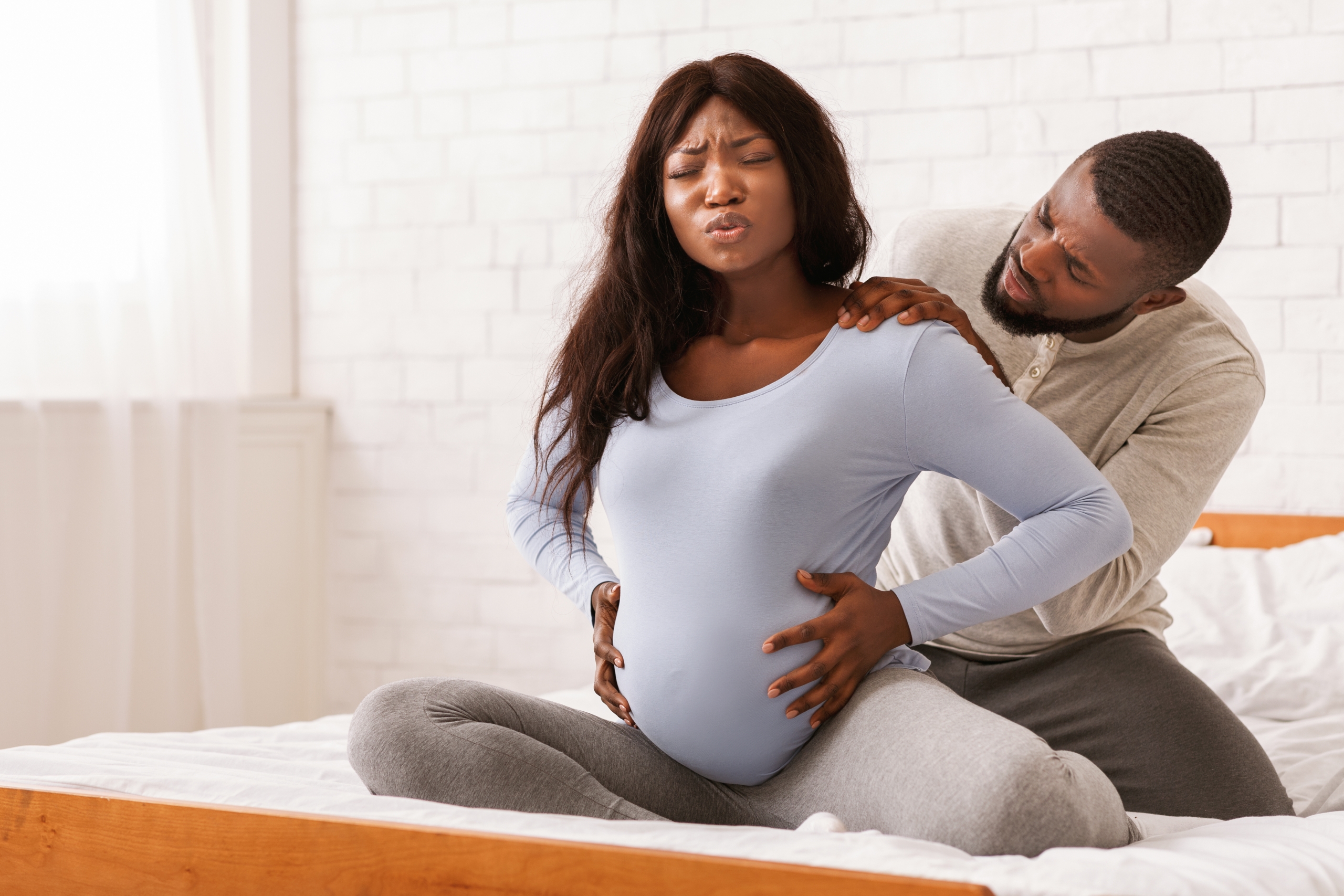 Pregnant woman with back or labor pains and her spouse.