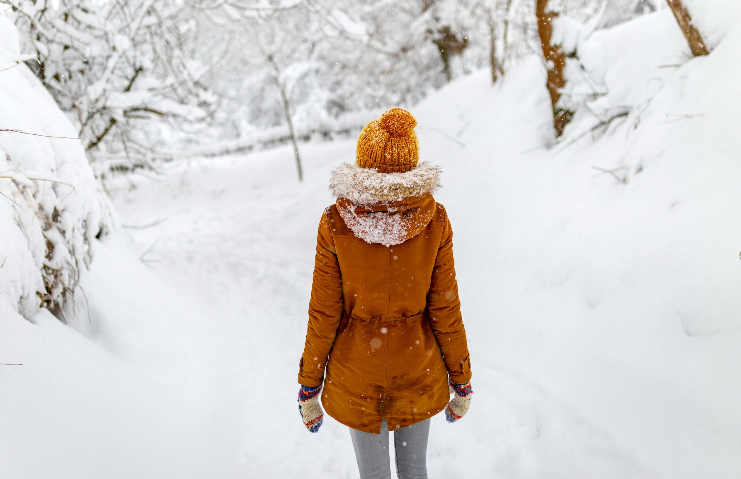 A woman walking in snowy, wintery weather.